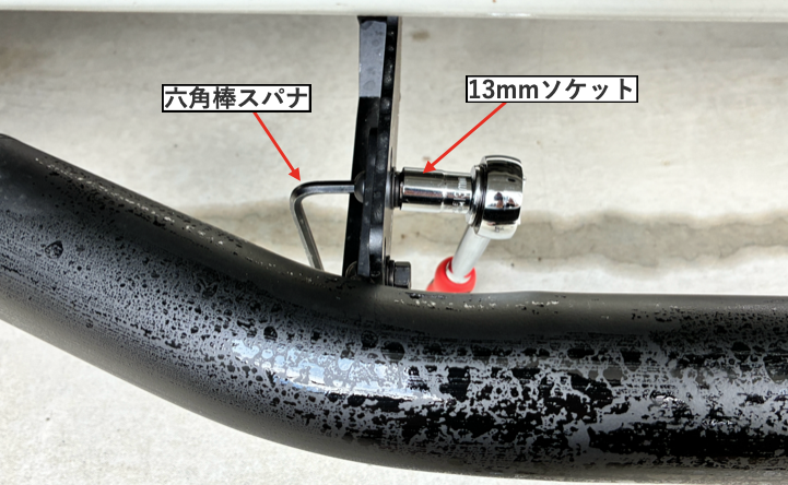 13mmソケットと六角棒スパナでサイドステップバーを固定している様子