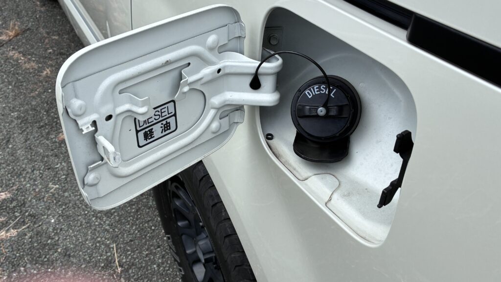 デリカD5の純正の給油口、黒いキャップに白いDIESELの刻印とフタ裏の軽油ステッカー