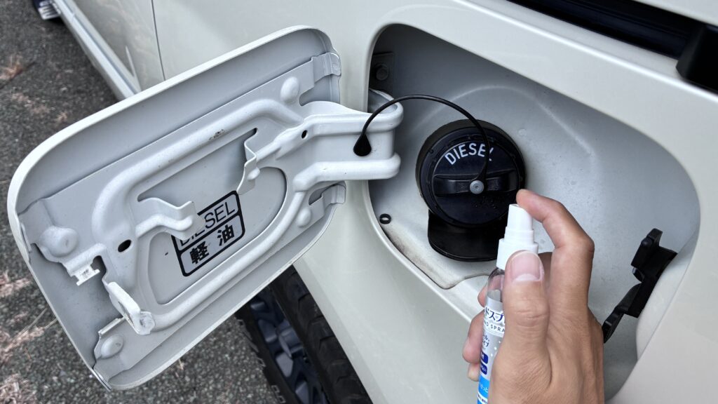デリカD5の給油キャップにアルコールスプレーを吹きかけて脱脂しているところ